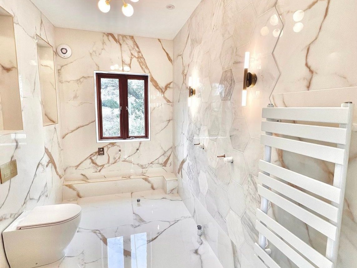 Luxury marble bathroom with wall lights and heated towel rail