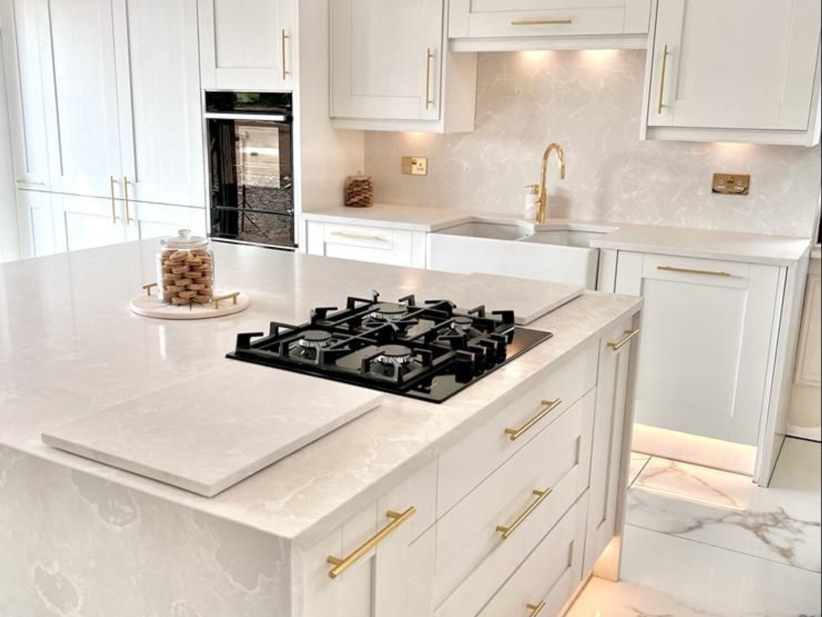 Modern white kitchen with under-cabinet lighting and gold fixtures